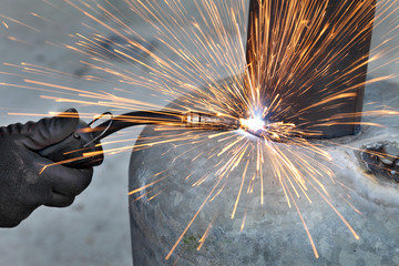 Fototapeta Arc welding of a steel, welder hands in gloves and tool obraz