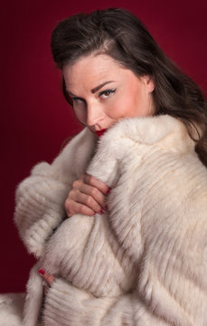 Pinup Girl Peers Over Collar of White Fur Coat