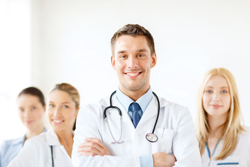 smiling male doctor in front of medical group