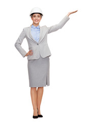 smiling businesswoman in helmet holding something