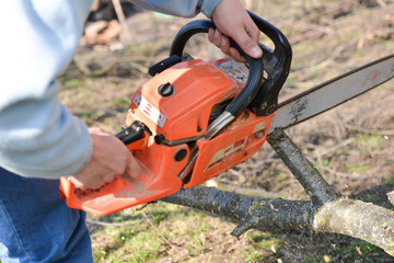 Lumberjack working with chainsaw, cutting wood. Selective focus