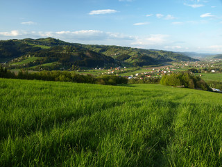 Green field above small village