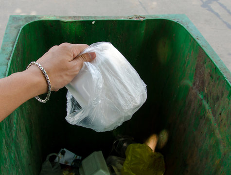 Hand throwing garbage in litter bin
