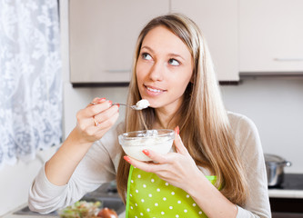  housewife in apron eating cottage cheese