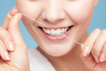 Girl cleaning teeth with dental floss. Health care