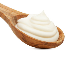 Cream in wooden spoon isolated on white background.