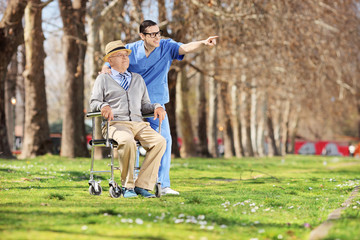 Male nurse showing something to a man in wheelchair