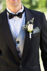 Midsection of groom wearing boutonniere