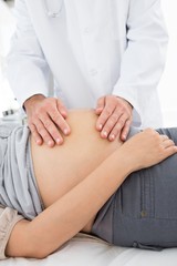 Male doctor examining expectant woman