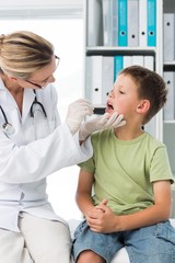 Fototapeta premium Doctor examining mouth of little boy