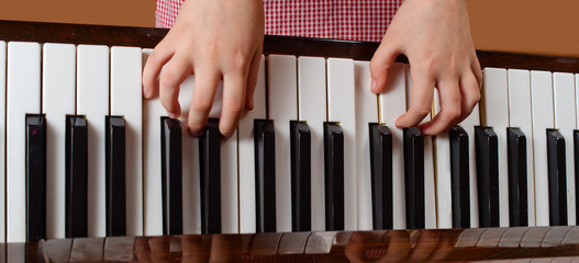 The child learns to play a piano