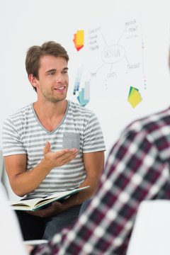 Young man talking to colleagues at a meeting