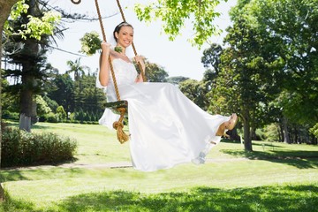 Young bride swinging in garden