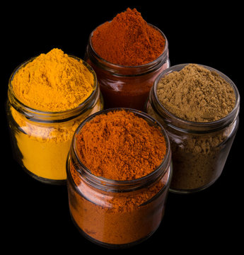 Mix powdered spices in glass container over black background