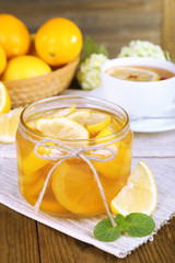 Tasty lemon jam with cup of tea on table close-up