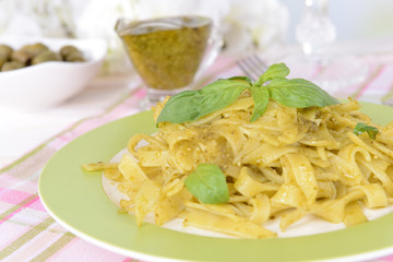 Delicious pasta with pesto on plate on table close-up