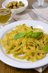 Delicious pasta with pesto on plate on table close-up