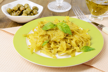 Delicious pasta with pesto on plate on table close-up