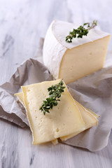 Tasty Camembert cheese with thyme, on wooden table