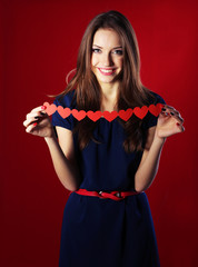 Naklejka premium Attractive woman with with paper garland, on color background