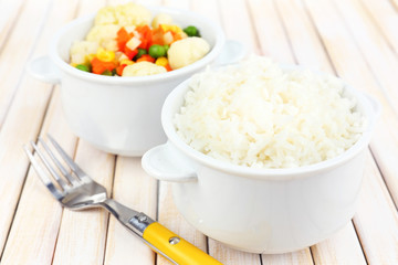 Cooked rice with vegetables on wooden table close up