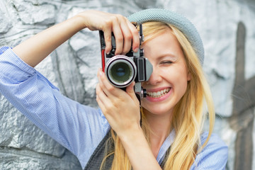 Portrait of young hipster taking photo with retro photo camera
