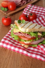 Tasty sandwich with ham on wooden table