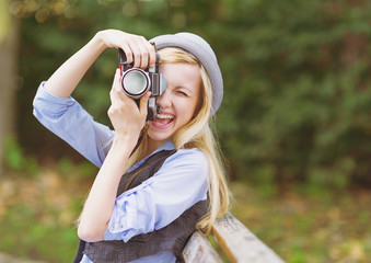 Young hipster taking photo with retro photo camera 