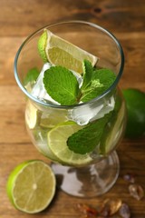 Ingredients for lemonade in glass, on wooden table