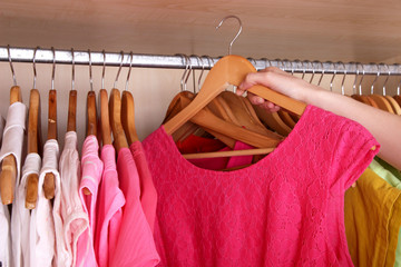 Colorful clothes hanging in wardrobe