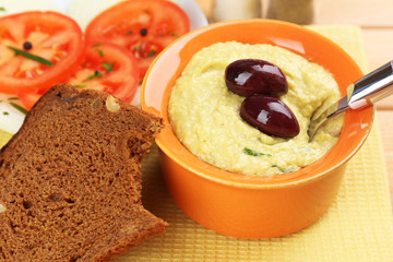 Bowl of tasty fresh hummus with olives