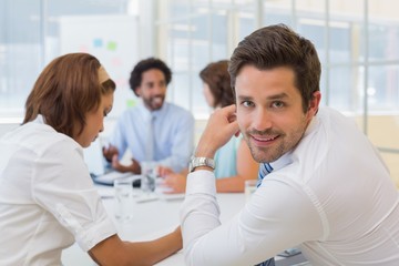 Fototapeta premium Smiling young businessman with colleagues in meeting