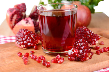 Ripe pomegranates with juice on table close-up