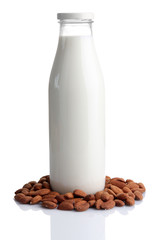 Almond milk in bottle with almonds, isolated on white
