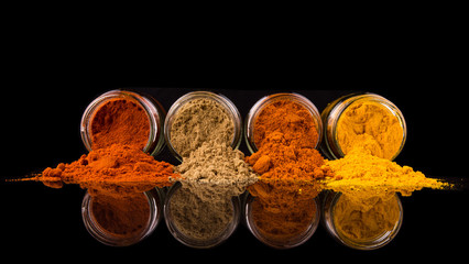 Mix powdered spices in glass container over black background - Powered by Adobe
