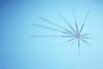 Fototapeta na wymiar Needles for acupuncture on blue background