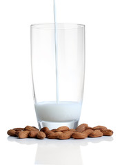 Almond milk is poured into glass, isolated on white