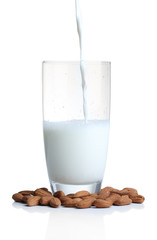Almond milk is poured into glass, isolated on white
