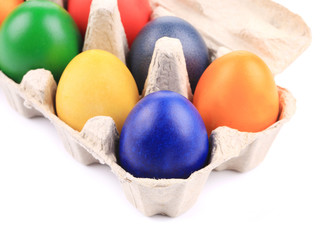 Fototapeta na wymiar Cardboard egg box with Easter colored eggs.