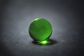 Green marble ball with reflection.