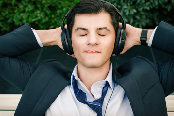 Businessman is relaxing in headphones - 63063209