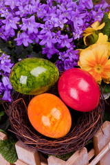three green and orange eggs in brown basket