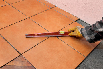 Home renovation, worker control tiles with level tool