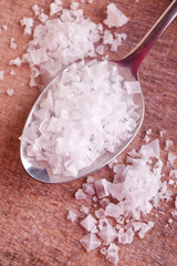 a spoon pyramid salt on wooden background