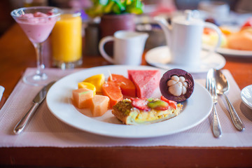 Philippino healthy breakfast with juicy fruits and black coffee