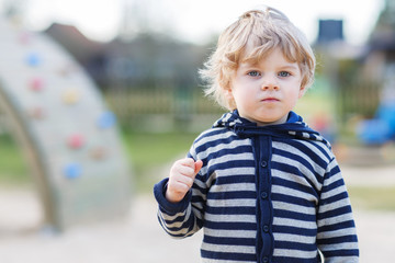 Portrait of toddler boy having fun on outdoor playground