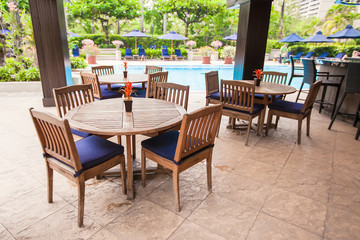 Fototapeta na wymiar Hotel na zewnątrz kawiarni z białego tabeli i krzesła w pobliżu basenu
