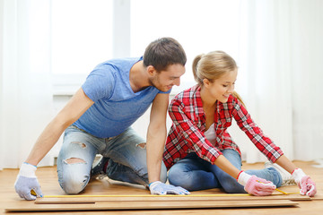 Fototapeta premium smiling couple measuring wood flooring
