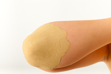 Die junge nackte Frau wird mit Heilerde behandelt