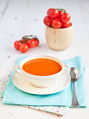Tomato soup with tomatoes on the background on the white table,